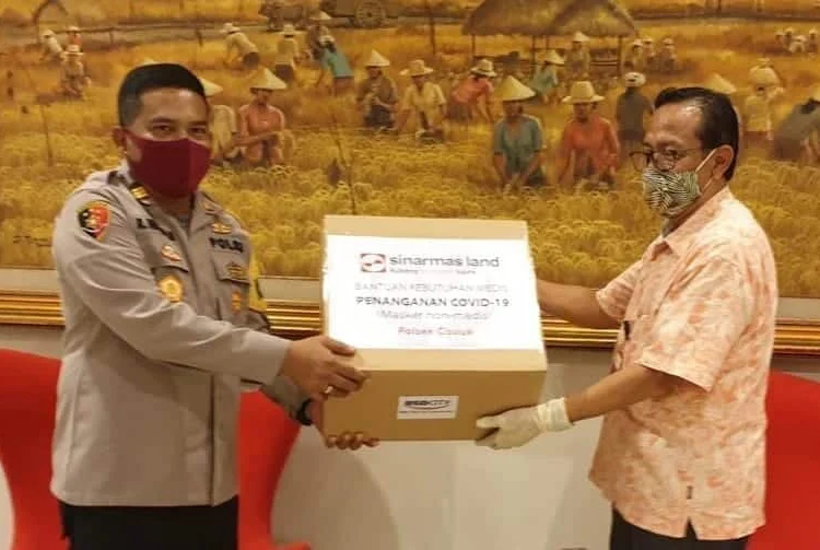 PEDULI: Head of Corporate Governance and Sustainability Sinar Mas Land Ignesjz Kemalawarta menyerahkan bantuan masker kain kepada apparat Polri. (ISTIMEWA)