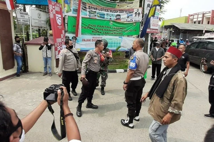 BERJAGA: Aparat kepolisian berjaga di lokasi bentrokan di kawasan Kecamatan Pinang, Kota Tangerang, Jumat (7/8). (IRFAN/SATELIT NEWS)