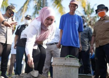 PELETAKAN BATU PERTAMA: Bupati Pandegalang Irna Narulita melakukan peletakan batu pertama dalam pembangunan Kampung Agraria di Kecamatan Panimbang, Sabtu (15/8). (ISTIMEWA)