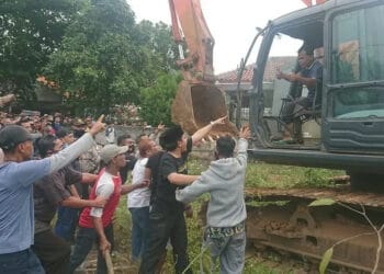 USIR ESKAVATOR : Puluhan warga memaksa ekskavator yang akan digunakan untuk pembebasan lahan pergi dari lokasi, Selasa (11/8). (IRFAN MAULANA/SATELIT NEWS)