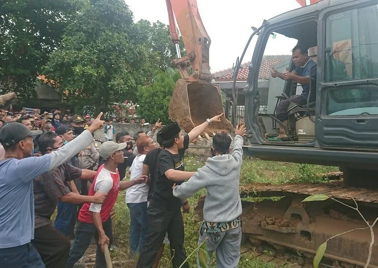 USIR ESKAVATOR : Puluhan warga memaksa ekskavator yang akan digunakan untuk pembebasan lahan pergi dari lokasi, Selasa (11/8). (IRFAN MAULANA/SATELIT NEWS)