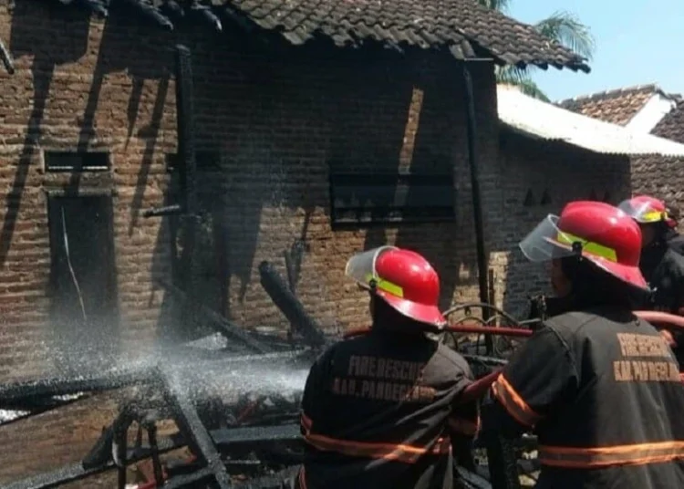 MEMADAMKAN API: Tim damkar BPBD Kabupaten Pandeglang sedang memadamkan api yang membakar rumah warga di Kampung Pasir Cau, Desa Karang Setra, Kecamatan Koroncong, Rabu (26/8). (NIPAL/SATELIT NEWS)