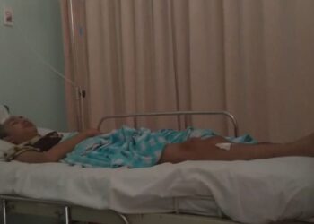 TERBARING : Putra Aji Adhari terbaring diri di salah satu rumah sakit di wilayah Ciledug. Putra menjadi korban pengeroyokan orang tak dikenal pada, Rabu, (22/7) lalu. (IRFAN MAULANA/ SATELIT NEWS)