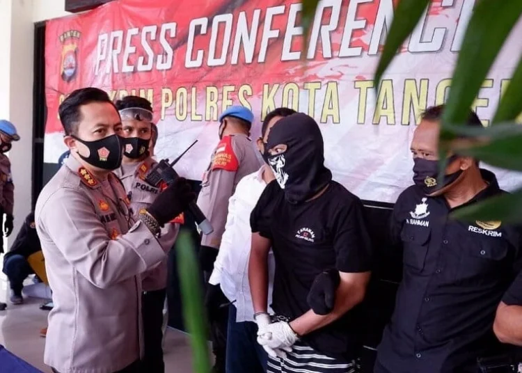 PRESS CONFERENCE: Kapolres Kota Tangerang Kombes Pol Ade Ary Syam Indradi sedang menginterogasi MT, salah satu tersangka kasus pencurian mobil, saat pres rilis di halaman Mapolres Kota Tangerang, Rabu (19/8). (ALFIAN /SATELIT NEWS)