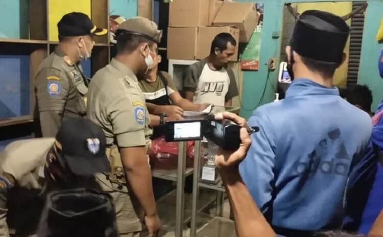 RAZIA: Satpol PP Pandeglang bersama anggota RPM Pandeglang sedang melakukan penggerebekan terhadap warung yang menjual Miras, Minggu (23/8). (NIPAL/SATELIT NEWS)