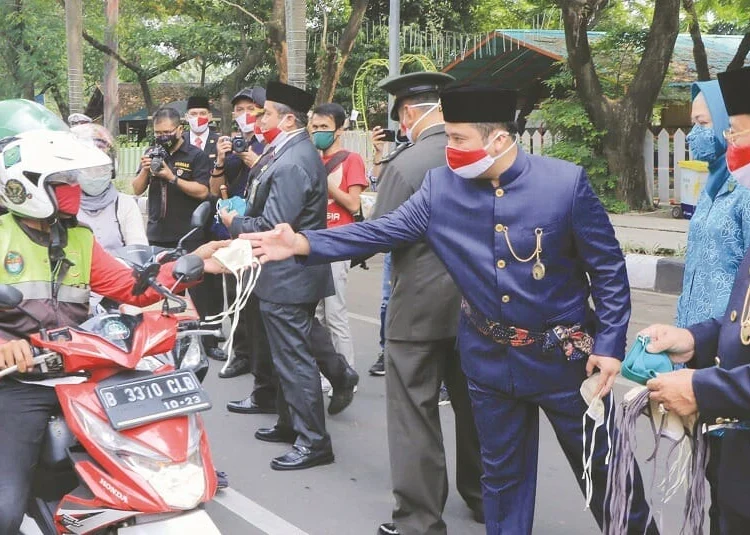 MASKER GRATIS: Walikota Tangerang Arief Wismansyah dan Wakil Walikota Tangerang Sachrudin saat membagikan masker kepada pengguna jalan dalam rangka HUT Kemerdekaan RI, Senin (17/8). (IRFAN/SATELIT NEWS)