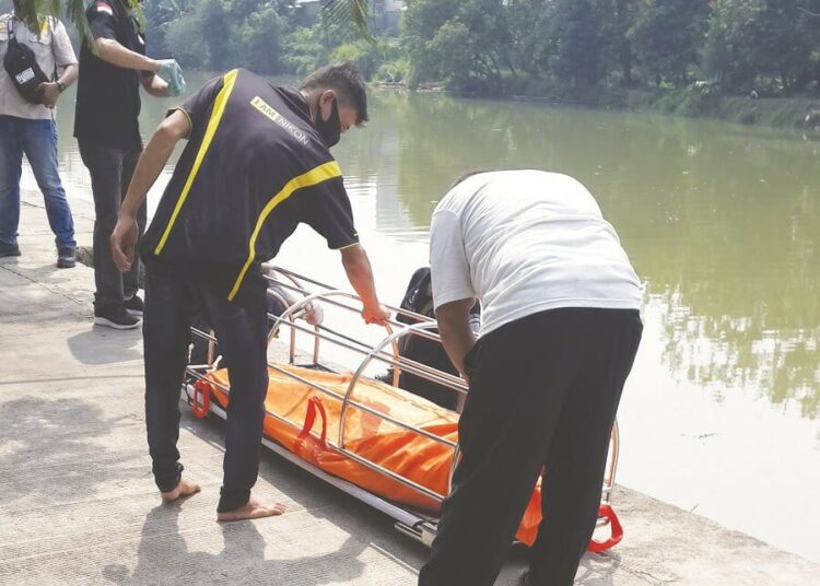 EVAKUASI: Sejumlah warga tengah mengevakuasi mayat yang mengapung di aliran sungai Cisadane, Kota Tangerang, Kamis (10/9). (IRFAN/SATELIT NEWS)