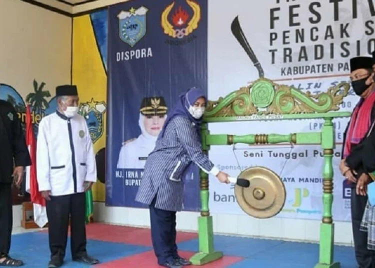 TABUH GONG: Bupati Pandeglang Irna Narulita secara simbolis membuka acara Festival Pencak Silat tradisional Kabupaten Pandeglang dengan menabuh gong, Minggu (13/9). (NIPAL/SATELIT NEWS)