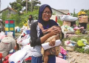 MENANGIS : Seorang ibu menangis sembari menggendong anaknya ketika rumahnya dirobohkan di Kampung Baru Kelurahan Jurumudi Kecamatan Benda Kota Tangerang, Selasa (1/9). (DEDE KURNIAWN/ SATELIT NEWS)