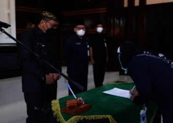 PELANTIKAN KEPSEK–Disaksikan Sekda Pandeglang, Pery Hasanudin, seorang perwakilan Kepsek menandatangani surat berita acara pelantikan, Jumat (9/7/2021). (NIPAL SUTIANA/SATELIT NEWS)
