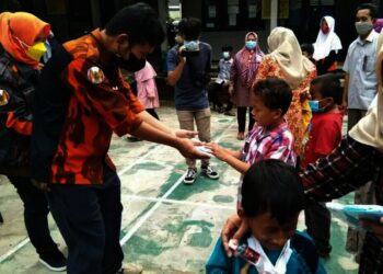 BAGIKAN BANTUAN - PC Sapma Kabupaten Pandeglang sedang memberikan bantuan kepada anak-anak berkebutuhan khusus di sekolah kebutuhan khusus Korpri Pandeglang, Jumat (23/7/2021). (NIPAL SUTIANA/SATELITNEWS.ID)