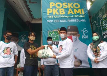 SALURKAN SEMBAKO - Ketua DPC PKB Kabupaten Pandeglang, Nawawi Nurhadi, menyalurkan bantuan paket sembako kepada warga, di posko PKB Aksi Melayani Isoman, Jumat (16/7/2021). (ISTIMEWA)