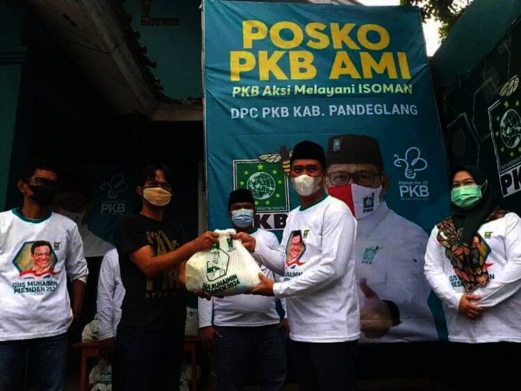 SALURKAN SEMBAKO - Ketua DPC PKB Kabupaten Pandeglang, Nawawi Nurhadi, menyalurkan bantuan paket sembako kepada warga, di posko PKB Aksi Melayani Isoman, Jumat (16/7/2021). (ISTIMEWA)