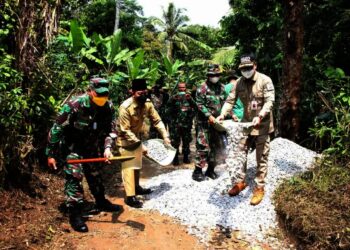 KERJASAMA–Melalui program Karya Bakti, jajaran TNI Kodim 0602/Serang, bekerjasama dengan DPUPR Kabupaten Serang dan masyarakat, membangun jalan sepanjang 278 meter di Kampung Calincing, Desa Cemplang,  Kecamatan Ciomas, Kabupaten Serang, Selasa (24/8/2021). (SIDIK/SATELITNEWS.ID)
