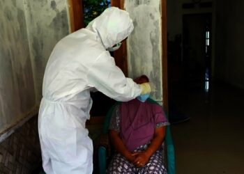 TES SWAB–Seorang petugas kesehatan, sedang melakukan swab tes kepada seorang warga yang kontak erat dengan orang positif Covid-19, Minggu (8/8/2021). (ISTIMEWA)