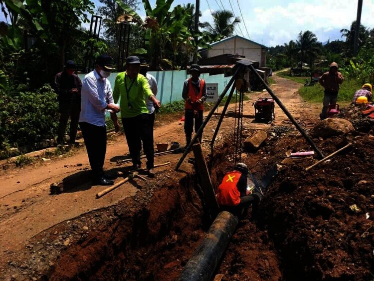 TINJAU LANGSUNG–Dirut PDAM Tirta Berkah Pandeglang, Ujang Sumawinata, didampingi jajarannya, sedang meninjau pengerjaan pemasangan pipa induk jaringan Cikoromoy, Rabu (25/8/2021). (ISTIMEWA)