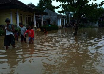 BANJIR - Sejumlah warga di Kecamatan Tunjungteja, Kabupaten Serang, melintasi banjir yang melanda wilayahnya, Selasa (9/8). (sidik/mardiana)
