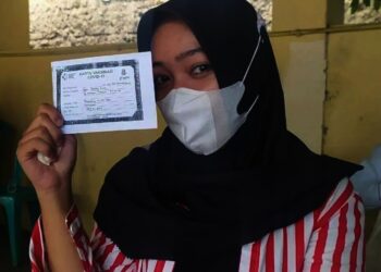 VAKSINASI PELAJAR–Seorang pelajar menunjukan kartu vaksinasi, yang masih berbentuk foto copy, usai divaksin di halaman Mapolsek Pandeglang Kota, Rabu (1/9/2021). (NIPAL SUTIANA/SATELITNEWS.ID)