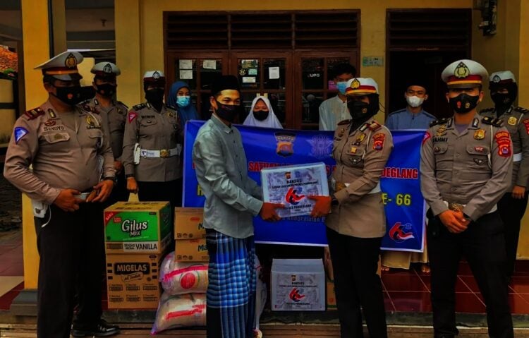 SERAHKAN BANTUAN–Kasat Lantas Polres Pandeglang, AKP Jeany Viadiniati, didampingi jajarannya sedang menyarahkan bantuan paket sembako ke Panti Asuhan Hasanudin, Pandeglang, Jumat (17/9/2021). (NIPAL SUTIANA/SATELITNEWS.ID)