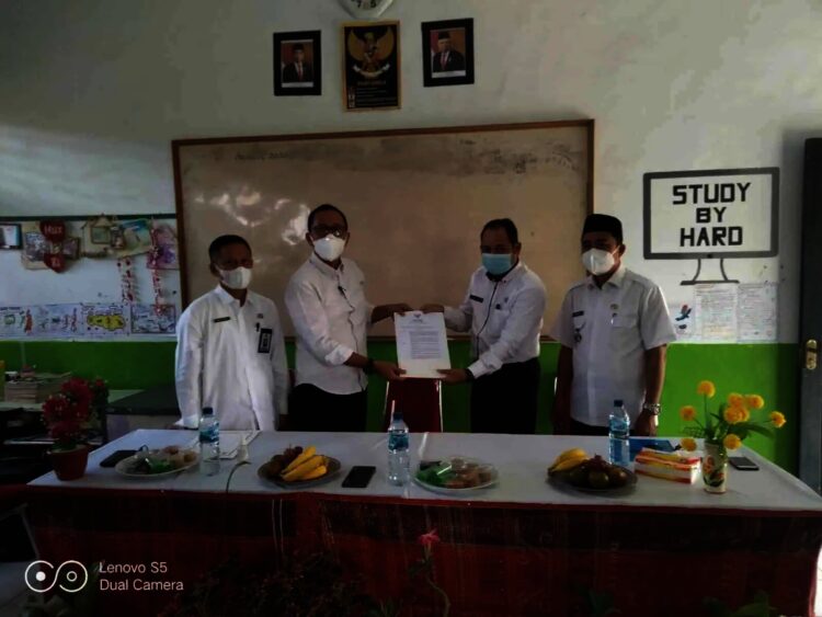 SERAHKAN SK–Kepala Dindikbud Kabupaten Serang, Asep Nugrahajaya (kiri), menyerahkan SK SDN Negeri Ciruas 5. Penyerahan tersebut, disaksikan oleh Camat Ciruas, Rabu (1/9/2021). (SIDIK/SATELITNEWS.ID)