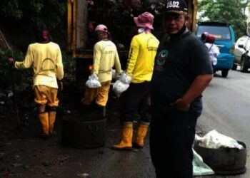 Petugas kebersihan mengangkut sampah di Jalan Raya Serang - Cilegon, tepatnya di Kecamatan Kramatwatu, belum lama ini. (ISTIMEWA)