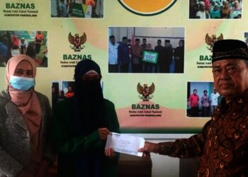 BERIKAN BANTUAN–Wakil Ketua Baznas Pandeglang, H.M. Acang, secara simbolis menyerahkan bantuan beasiswa kepada seorang mahasiswa, di kantor Baznas Pandeglang, Selasa (12/10/2021). (ISTIMEWA)
