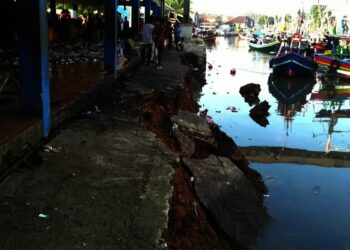 AMBROL–Tembok Penahan Tanah (TPT) Tempat Pelelangan Ikan (TPI) 3 Labuan, yang dijadikan dermaga sandaran kapal, di Kampung Pasar Baru, Desa Labuan, Kecamatan Labuan, rusak parah, Rabu (13/10/2021). (ISTIMEWA)