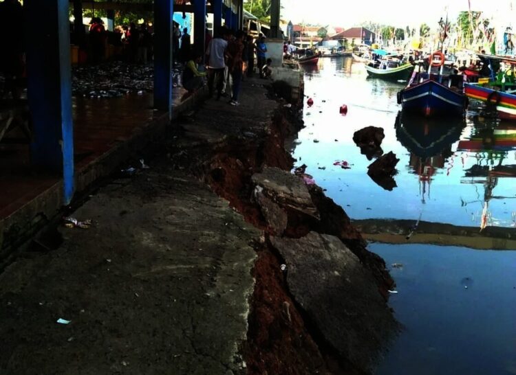AMBROL–Tembok Penahan Tanah (TPT) Tempat Pelelangan Ikan (TPI) 3 Labuan, yang dijadikan dermaga sandaran kapal, di Kampung Pasar Baru, Desa Labuan, Kecamatan Labuan, rusak parah, Rabu (13/10/2021). (ISTIMEWA)