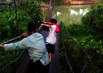AMBROL–Diduga akibat ulah orang yang tak bertanggungjawab, jembatan gantung penghubung Desa Pasirloa, Kecamatan Sindangresmi dan Kampung Sawera, Desa Karyasari, Kecamatan Sukaresmi, ambrol, Jumat (15/10/2021) malam lalu. (ISTIMEWA)