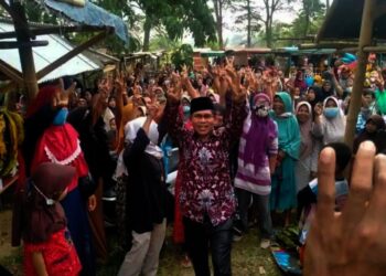 Sejumlah warga bersorak bahagia, dengan mengangkat tangan, atas kemenangan Calkades Kopo, Sapri, Senin (1/11/2021). (ISTIMEWA)
