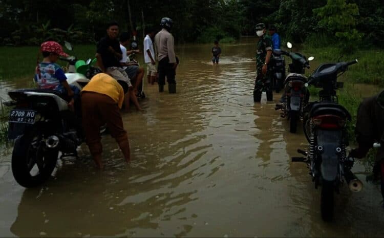 TERGENANG–Genangan air yang merendam jalur di wilayah Kecamatan Patia, dimanfaatkan warga untuk mencuci kendaraan, Senin (22/11/2021). (ISTIMEWA)