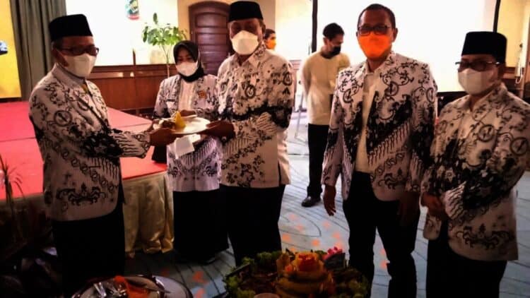 Wakil Bupati Serang Pandji Tirtayasa (kanan), memberikan potongan tumpeng kepada Ketua PGRI Kabupaten Serang (kiri), saat memperingati HUT PGRI di salah satu hotel di Anyer, Kamis (25/11/2021). (ISTIMEWA)