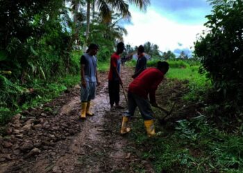 PERBAIKI JALAN–Mantan Calkades Kalang Gunung, Kecamatan Cipeucang, Ade Faruq bersama sejumlah pekrja, sedang memperbaiki ruas jalan Desa Curug Barang – Kalang Gunung, yang kondisinya rusak parah, Minggu (14/11/2021). (ISTIMEWA)