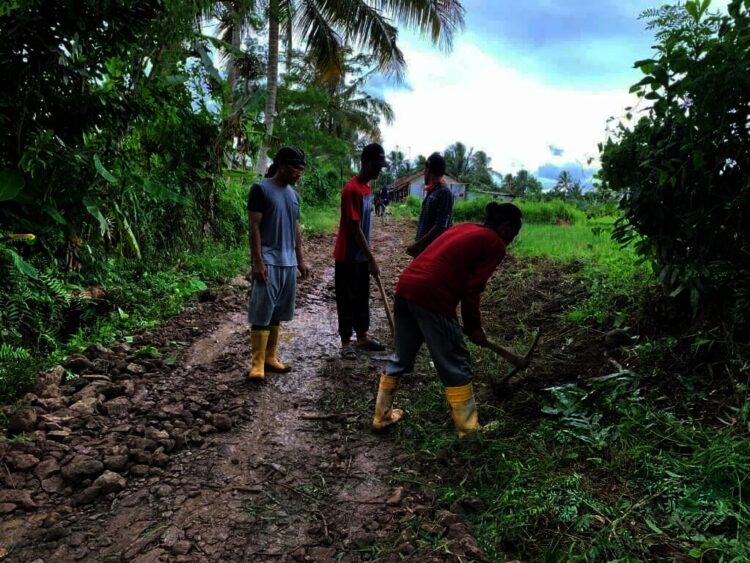 PERBAIKI JALAN–Mantan Calkades Kalang Gunung, Kecamatan Cipeucang, Ade Faruq bersama sejumlah pekrja, sedang memperbaiki ruas jalan Desa Curug Barang – Kalang Gunung, yang kondisinya rusak parah, Minggu (14/11/2021). (ISTIMEWA)