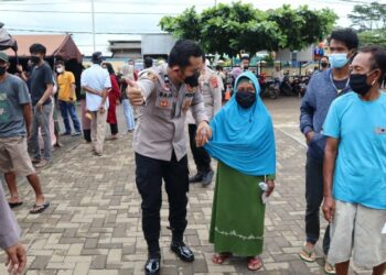 PELAYANAN–Personel Polres Pandeglang, mendampingi lansia agar mendapatkan layanan vaksinasi secara cepat dan maksimal, di Kecamatan Panimbang, Sabtu (27/11/2021). (ISTIMEWA)