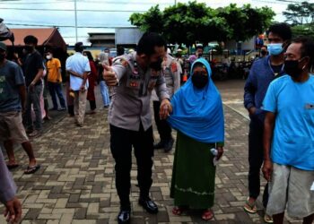 PELAYANAN–Personel Polres Pandeglang, mendampingi lansia agar mendapatkan layanan vaksinasi secara cepat dan maksimal, di Kecamatan Panimbang, Sabtu (27/11/2021). (ISTIMEWA)