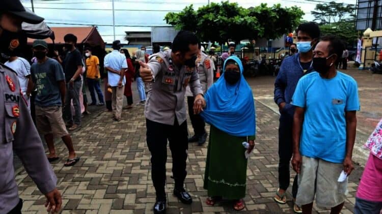 PELAYANAN–Personel Polres Pandeglang, mendampingi lansia agar mendapatkan layanan vaksinasi secara cepat dan maksimal, di Kecamatan Panimbang, Sabtu (27/11/2021). (ISTIMEWA)