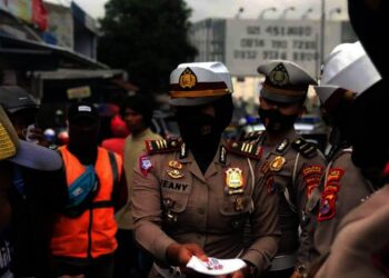 Kepala Satuan (Kasat) Lantas Polres Pandeglang, AKP Jeany Viadiniati, sedang membagikan masker kepada masyarakat di Pasar Pandeglang, beberapa waktu lalu. (ISTIMEWA)