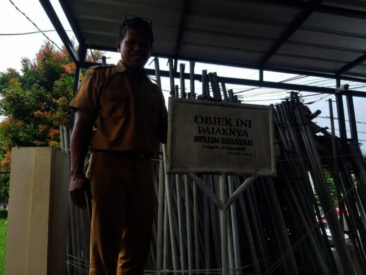 Kepala Bidang Penetapan DP2D Pandeglang, Muklis Arifin, sedang mengecek plang yang diperuntukan bagi penunggak pajak. (ISTIMEWA)