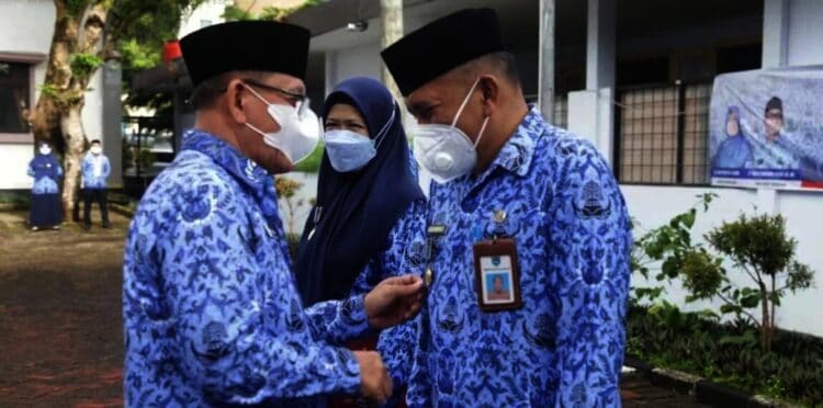 Pj Sekda Pandeglang, Taufik Hidayat, secara simbolis memasangkan lencana kepada pejabat yang berhak, di halaman Setda Pandeglang, Senin (29/11/2021). (ISTIMEWA)