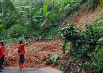 Personel BPBD Kabupaten Serang, mengecek kondisi longsor yang menutup akses jalan di Desa Pakuncen, Kecamatan Bojonegara, Senin (17/1/2022). (ISTIMEWA)