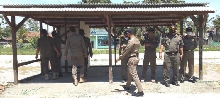 Anggota Satpol PP Kabupaten Serang, memberikan teguran ke seorang pemilik bangunan liar yang berdiri di pinggir saluran irigasi Pamarayan, di Kecamatan Kibin, Kabupaten Serang, Selasa (4/1/2021). (ISTIMEWA)