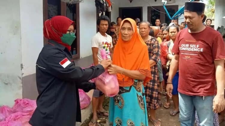 PENYALURAN BANTUAN–Kepala Desa (Kades) Idaman, Ilman, mendampingi dan menyaksikan penyaluran bantuan kepada para korban banjir di Desa Idaman, Kecamatan Patia, Kabupaten Pandeglang, Minggu (13/3/2022). (ISTIMEWA)