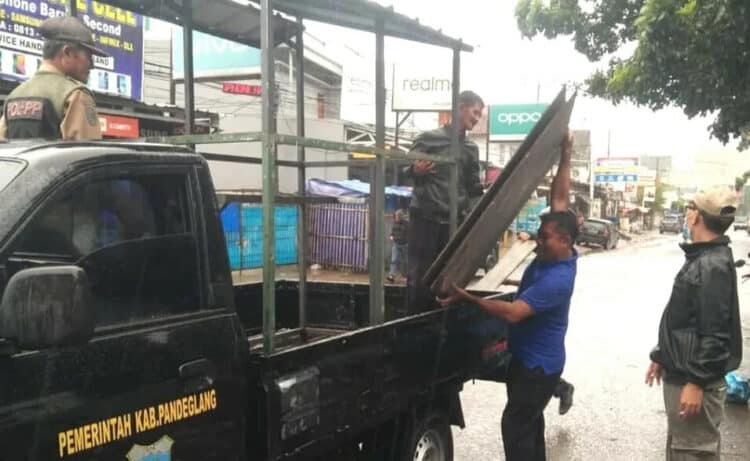 Sejumlah petugas Pol PP dan Muspika Labuan, sedang menertibkan PKL yang berjualan disekitar eks Puskesmas Labuan, Senin (7/3/2022). (ISTIMEWA)