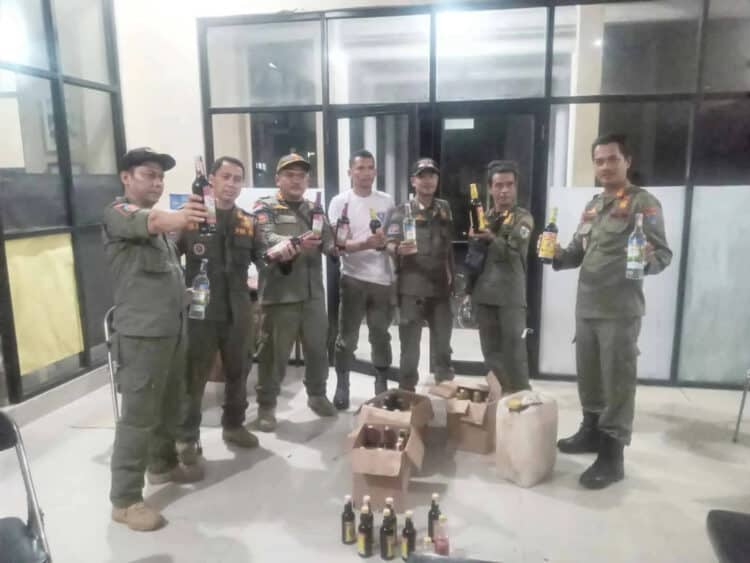 Jajaran personel Satpol PP Pandeglang, menujukkan miras hasil operasi pekat di dua Kecamatan di Kabupaten Pandeglang, Selasa (8/6/2022) malam. (ISTIMEWA)