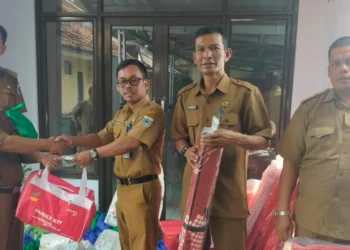 Sekretaris Dinsos Pandeglang, Muslim Taufik, serahkan bantuan untuk korban banjir di Desa Pancaran, Kecamatan Munjul, Kabupaten Pandeglang, Senin (20/6/2022). (ISTIMEWA)
