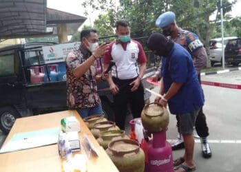 Pelaku mempraktekan cara menyuntikkan Gas Subsidi yang ke Tabung 12 Kilogram, dihadapan petugas, Minggu (17/7/2022).(ISTIMEWA)