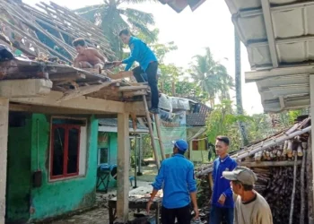 Anggota KSB Angsana bersama warga dan pemilik rumah, sedang merapihkan atap rumah yang roboh akibat angin kencang, Kamis (21/7/2022). (ISTIMEWA)