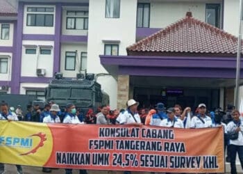 UNJUK RASA: Buruh membentangkan spanduk saat melakukan aksi unjuk rasa di depan Kantor Dinas ketenagakerjaan Kabupaten Tangerang, Kamis (17/11). (ALFIAN/SATELIT NEWS)