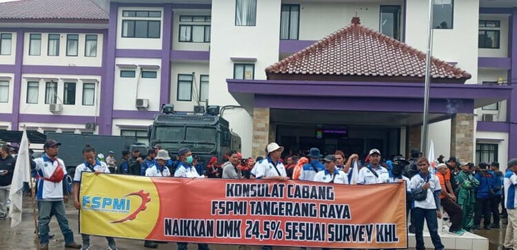 UNJUK RASA: Buruh membentangkan spanduk saat melakukan aksi unjuk rasa di depan Kantor Dinas ketenagakerjaan Kabupaten Tangerang, Kamis (17/11). (ALFIAN/SATELIT NEWS)